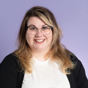 Headshot of Heather, a white woman with highlighted blonde hair and glasses. 