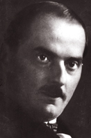 A black and white photograph of a stern-faced moustached man, looking past the camera to its right.