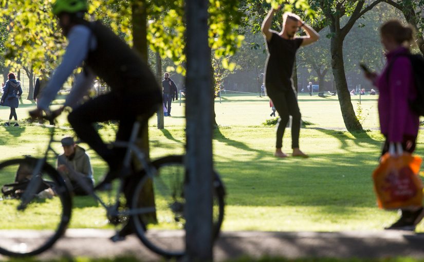 park scene with cyclist and male exercising