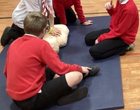 School children practising CPR