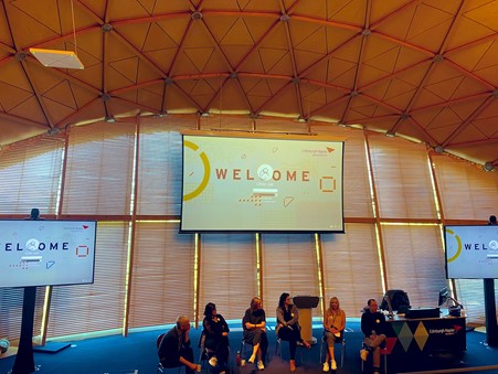 the VME panel sitting in front of a sign saying 'welcome'